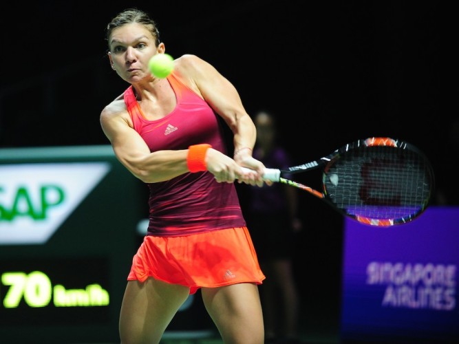 Simona Halep of Romania returns the ball to Falvia Pennetta of Italy during their season-ending tennis WTA Final in Singapore on October 25, 2015. AFP PHOTO / MOHD FYROLMOHD FYROL/AFP/Getty Images
